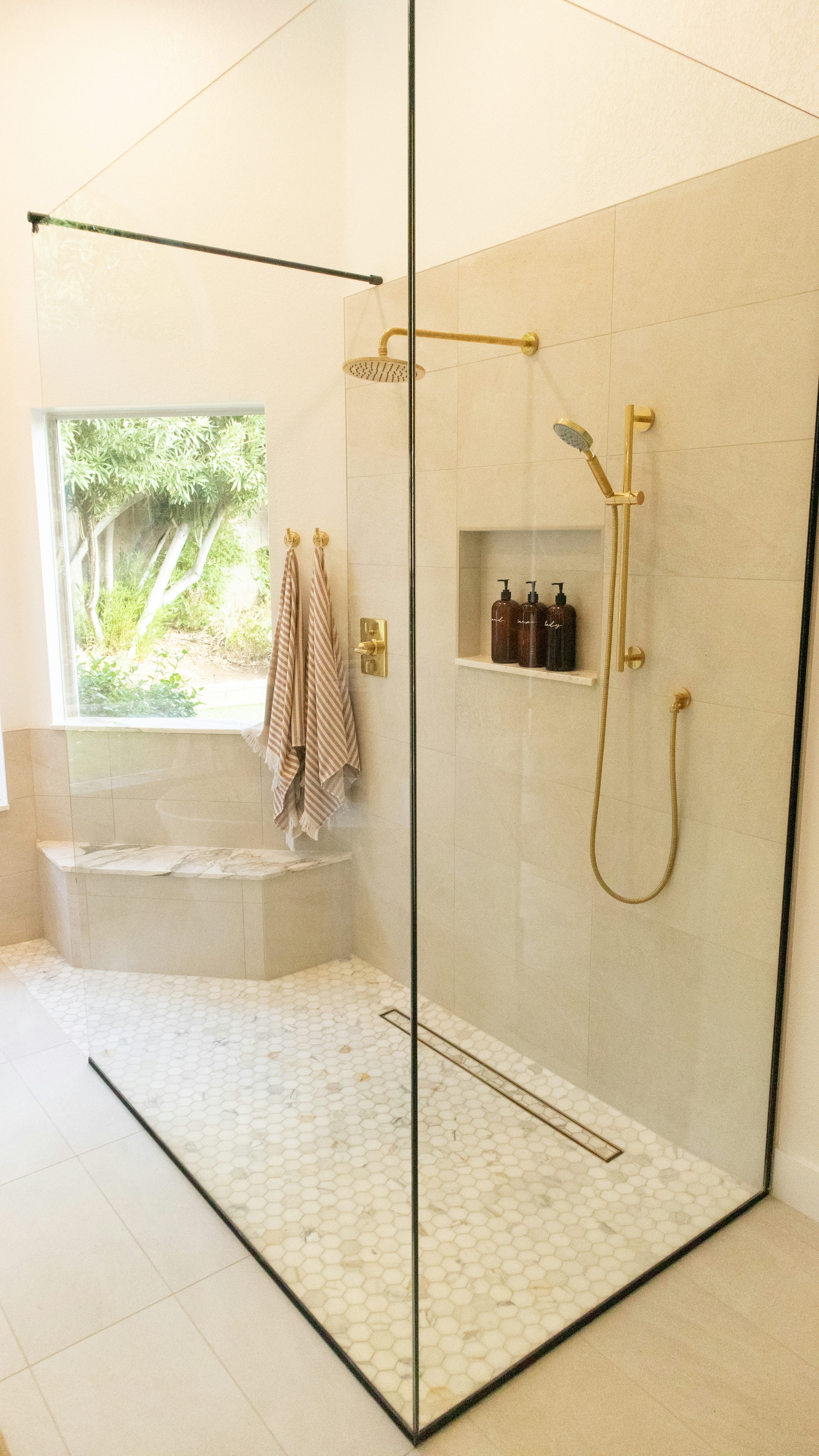 Warm tiled shower with mosaic floor and clean grout lines