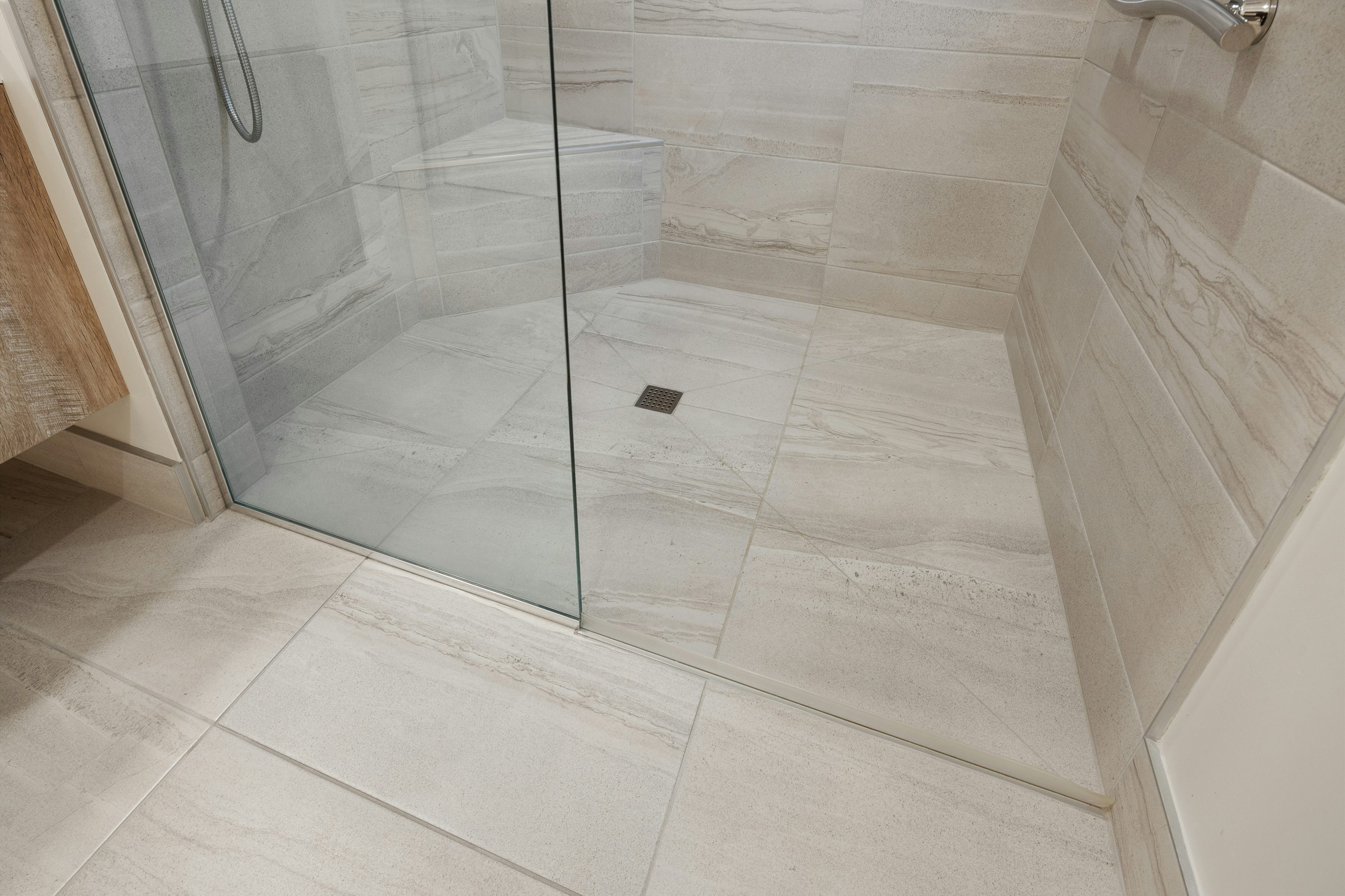 Close view of precisely aligned porcelain shower tiles and clean transition